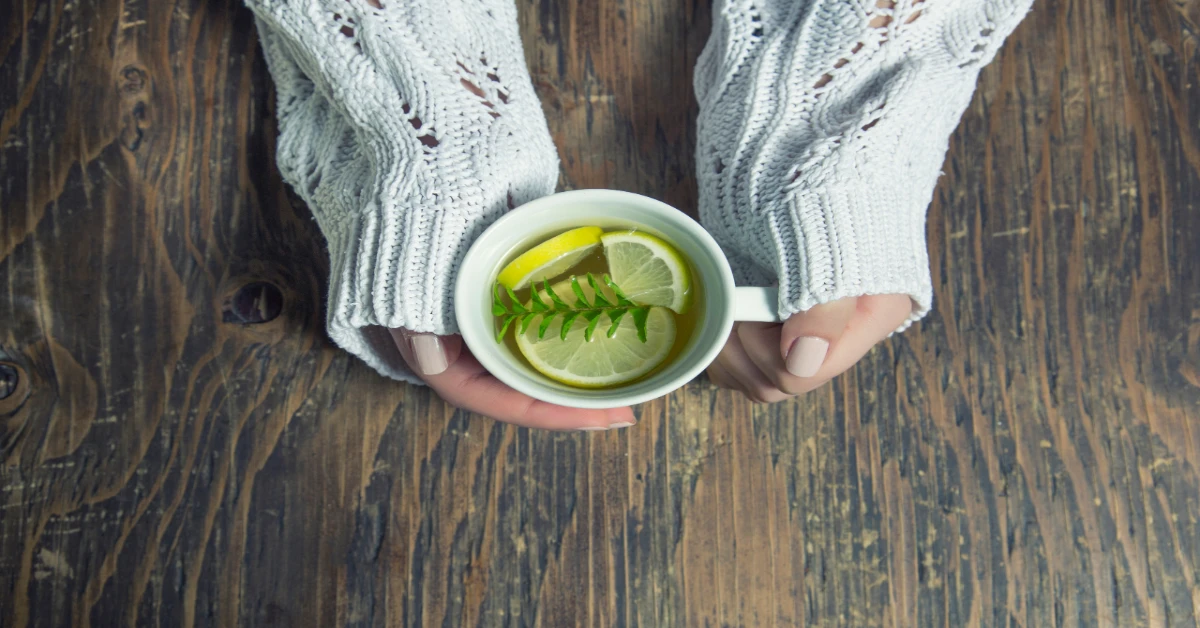 Woman holding a cup with lemon tea