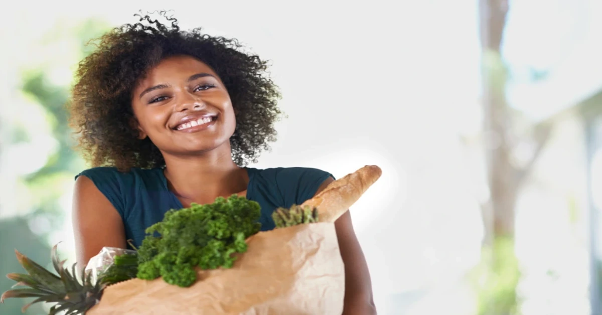 a woman holding a brown paper bag